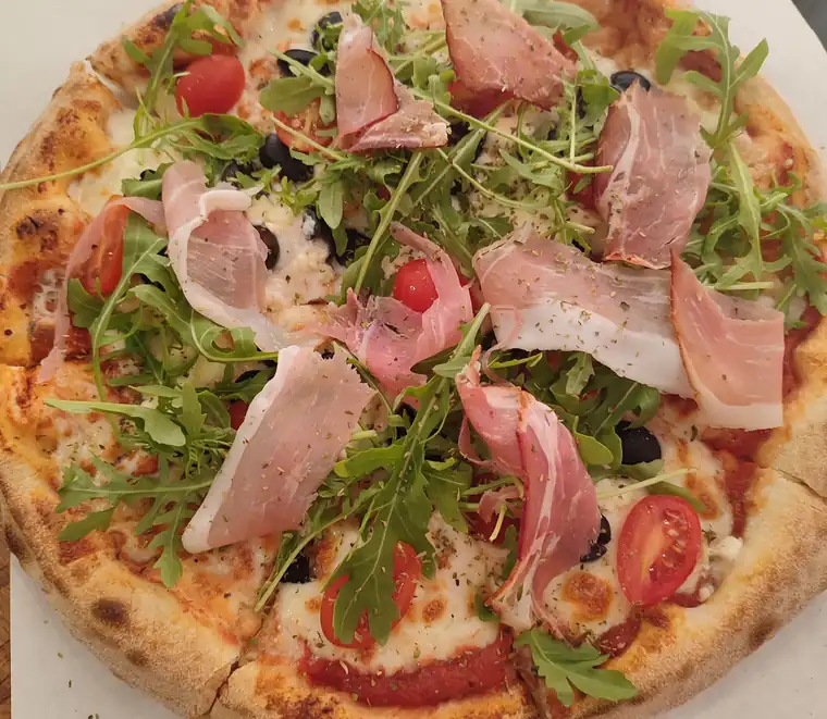 Pizza z szynką parmeńską, rukolą i pomidorkami