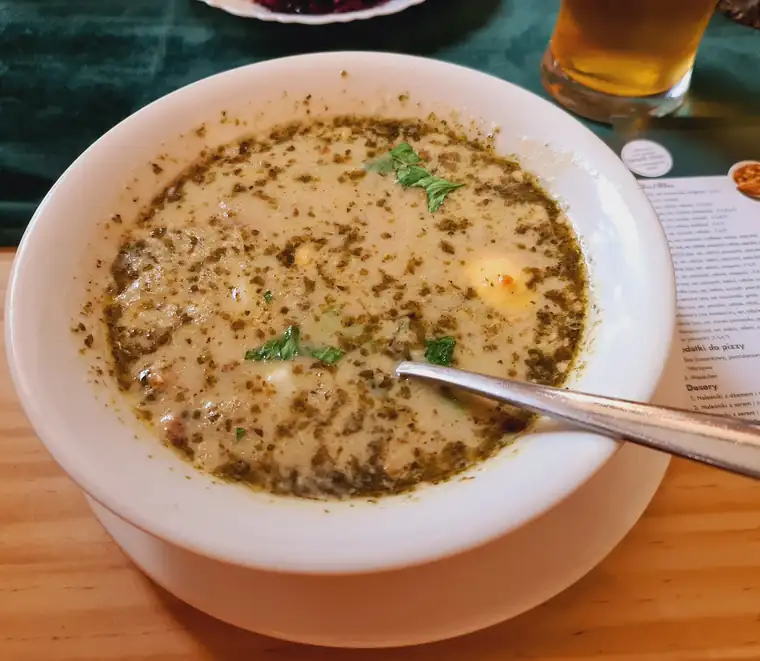 Zupa z makaronem i natką w białym talerzu